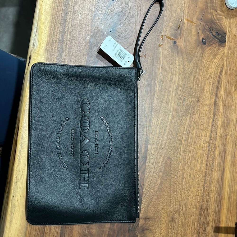 Black coach wristlet never used.  Spot for credit cards